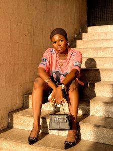 Sporty jorts outfit styled with a jersey, black shoes, scarf and bag