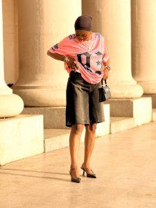 Sporty jorts outfit styled with a jersey, black shoes, scarf and bag